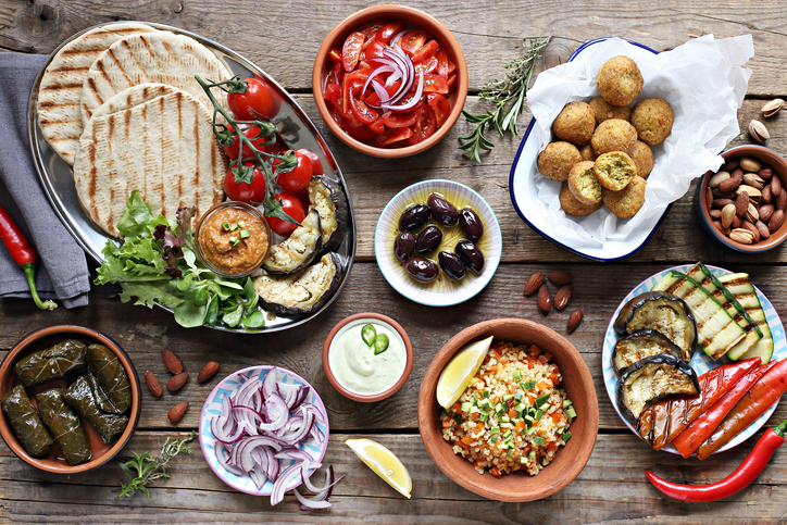 Middle eastern, arabic or mediterranean appetizers table concept Middle eastern, arabic or mediterranean appetizers table concept with falafel, pita flatbread, bulgur and tomato salads, grilled vegetables, stuffed grape leaves,olives and nuts.
